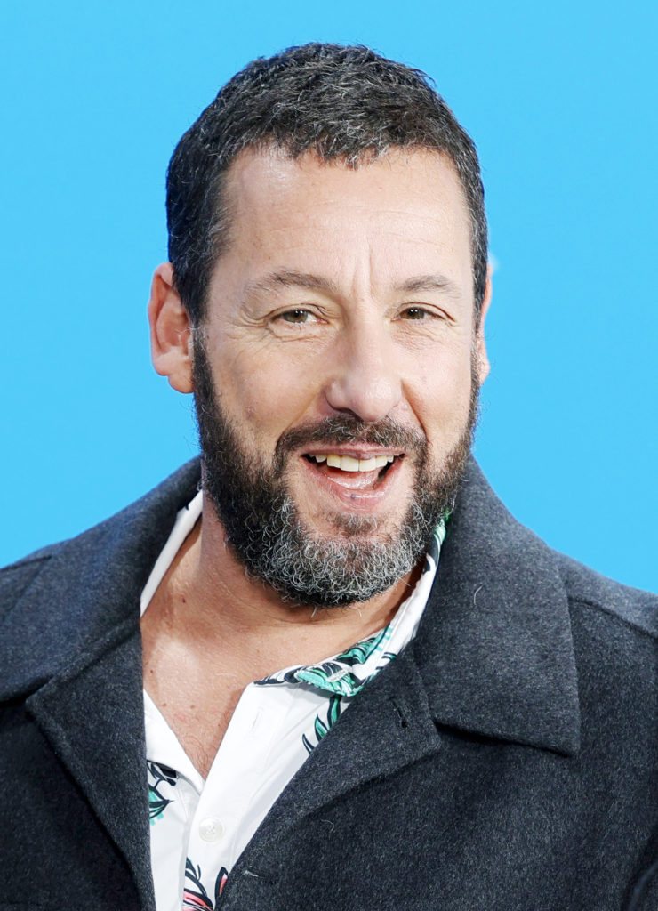 Adam Sandler bei einem öffentlichen Auftritt 2024 mit Bart und dunklem Mantel – Porträtaufnahme vor blauem Hintergrund Von Elena Ternovaja - Eigenes Werk, CC BY-SA 3.0, Link