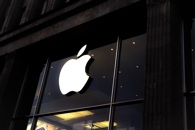 Apple Store mit leuchtendem Apple Logo an der Glasfassade